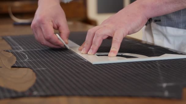 Taillez des lignes de dessin sur un tissu avec sa craie afin de créer un profil plat sur mesure avec un tissu en laine anthracite. ce styliste travaillant dans la boutique, dessin & modèles de coupe . — Video