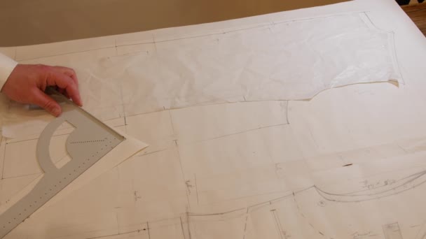 Patrón de traje de dibujo de sastrería Dressmaker profesional, patrón de medición y dibujo en papel en el taller para futura chaqueta o traje. Costura de moda en el estudio en 4K — Vídeo de stock