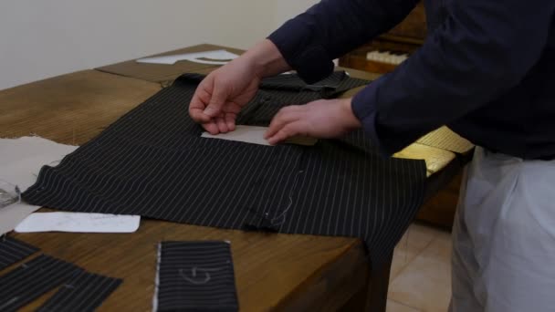 Snygg medelålders man Mode designer händer placera gränssnitt tyg innan utformningen av luckan fickor i denna jacka. — Stockvideo
