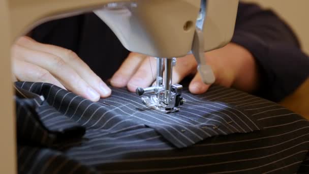 Mani stilista cucire tessuto abito nero. Luogo di lavoro della sarta. Tagli e cuciture sartoriali e da tailleur secondo linee di schizzo . — Video Stock