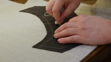 Terzi tasması. Dikiş ya da süsleme kalıcı olarak dikebilene kadar yerleştirilir, genellikle raptiye dikişi ya da dikiş adı verilen el ya da makine tarafından yapılan uzun bir dikişle..