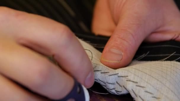 Schneiderpolster nähen Revers und Unterkragen einer Jacke, um ihnen zusätzliche Festigkeit zu verleihen und ihre Krümmung zu erhalten — Stockvideo