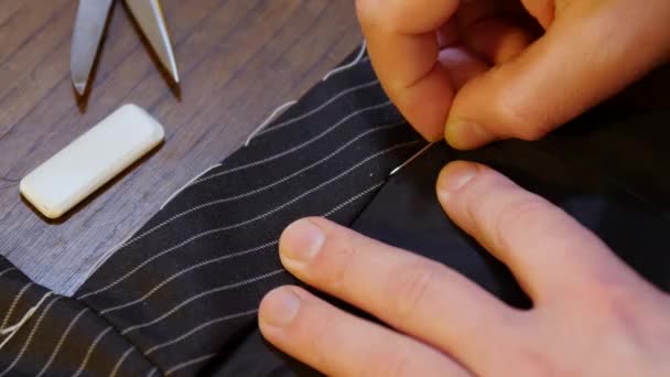 Costume alfaiataria tradição artesanal: Costurar um terno jaqueta preta sob medida. Imagem de close-up — Vídeo de Stock