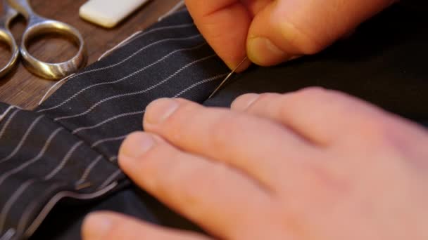 Tradição de alfaiataria: movimento profissional de costura jovem alfaiate mão com uma agulha e linha à mão de acordo com a antiga tradição — Vídeo de Stock