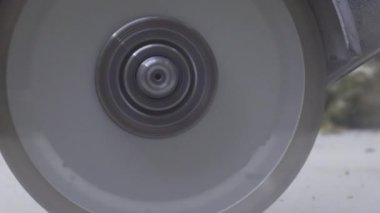 Profesyonel elektrikli beton öğütücü kullanan bir işçinin elleri. Bu kesme makinesi beton yolu ya da zemini kesmek için elmas testeresi kullanıyor. Kirli toz havada yayılıyor,