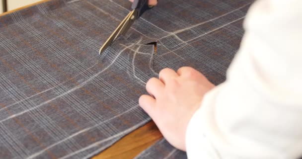 Люди, сшивание, рукоделие, шитье и пошив концепции: человек с портной ножницы или ножницы вырезать ткань в студии синей шерсти ткани для изготовления костюмов. Dressmaker создает новый продукт . — стоковое видео