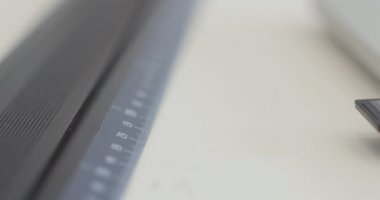 Kadın kıyafetleri, çizimler ve dikiş makineleri görünür. Erkek moda tasarımcısı dizüstü bilgisayarla yeni kıyafetler çiziyor. Stüdyodaki masada otururken moda giysiler yaratıyor. başarılı insanlar