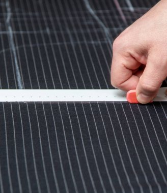 Ölçüm çubuğuyla çalışan terzi elleri. Dikiş atölyesindeki terzi. Kıyafet yapma süreci. Tekstil kumaşının yüzeyine yakın çekim ve dikiş aletleri.