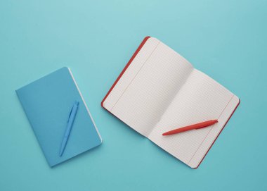 Mavi arka planda bir defter, okula geri dönüş, öğrenci aksesuarları, bir yazıt için boş alan, düz uzan