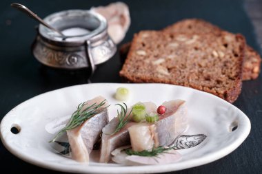 Soğan ve kahverengi ekmekle dilimlenmiş İskandinav ringası.