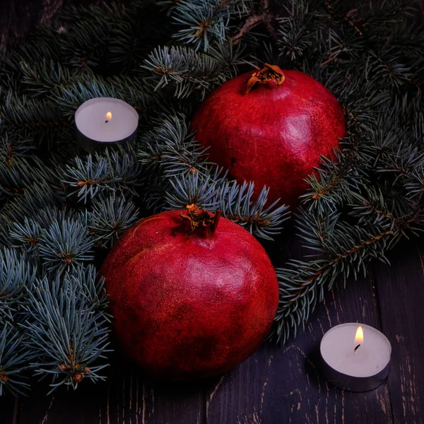 Pomegranate with Christmas decorations on dark background — Stock Photo, Image