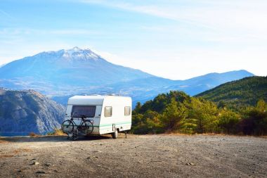 Bir dağın tepesinde bir bisiklet ile karavan Park 