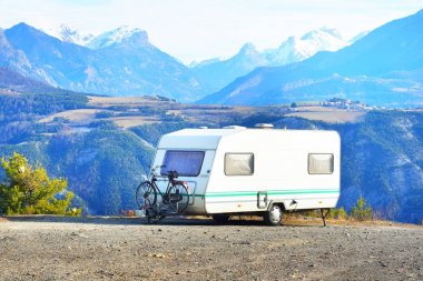 Bir dağın tepesinde bir bisiklet ile karavan Park 