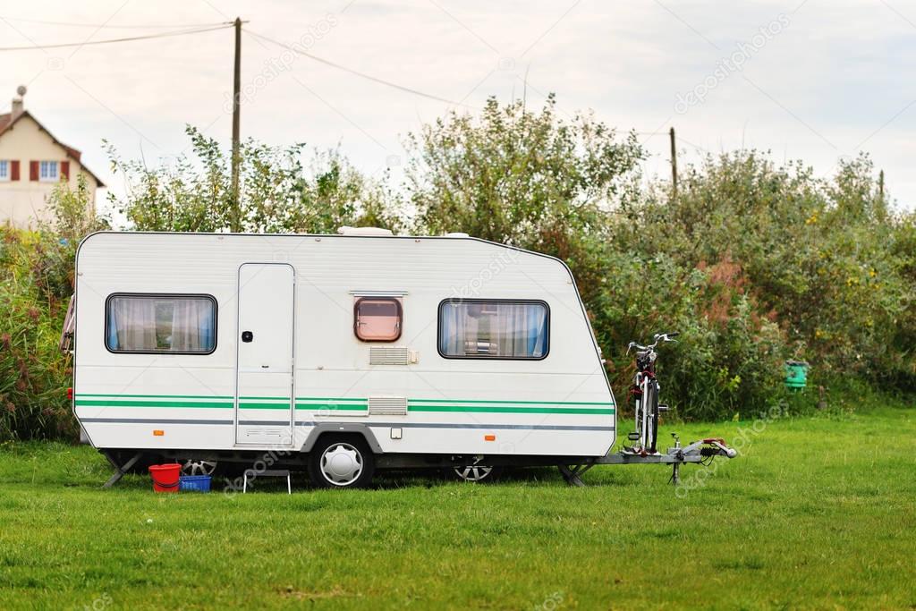 Caravan trailer on a green lawn at the camping 
