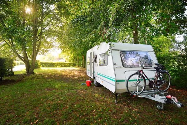 Caravan trailer på en gräsmatta under träden — Stockfoto