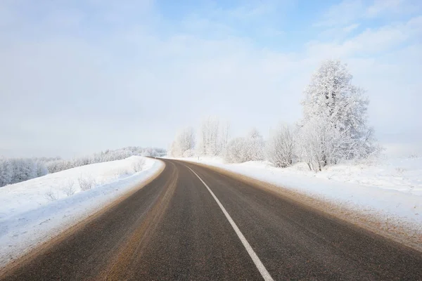 Estrada de inverno rural em um dia ensolarado — Fotografia de Stock