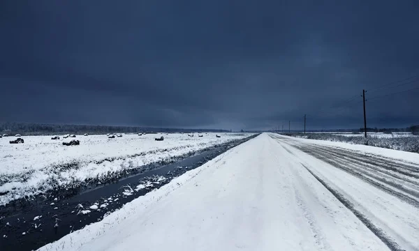 在雪下的水渠附近的碎石路 — 图库照片