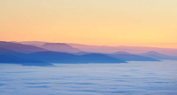 Vue sur le coucher du soleil dans les montagnes et les vallées avec brouillard — Photo