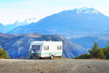 Bir dağın tepesinde bir bisiklet ile karavan Park 