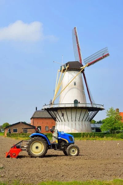 Klasické holandské krajiny s větrný mlýn a traktor — Stock fotografie