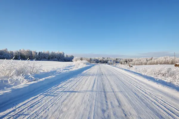 Estrada rural coberta de neve no inverno — Fotografia de Stock