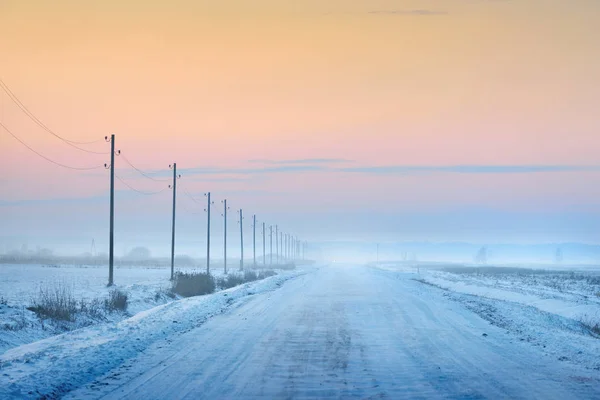 Countryside road with telegraph poles in winter — Stock Photo, Image