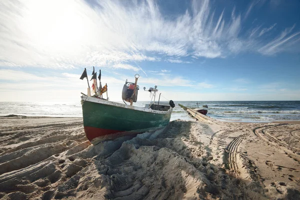 Green patrol boat with flags on a beach