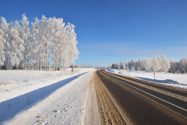 Estrada de inverno rural em um dia ensolarado — Fotografia de Stock