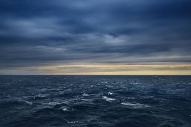 Denizde bir günbatımı üzerinde offshore rüzgar türbinleri ile deniz manzarası