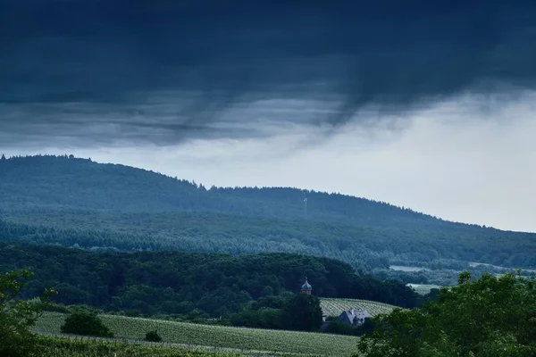 Almanya, Pfalz mavi tepe köy ve orman üzerinde siyah fırtınalı bulutlar kaplı