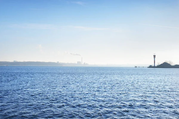 Bir uzak cityscape karşı küçük deniz feneri — Stok fotoğraf