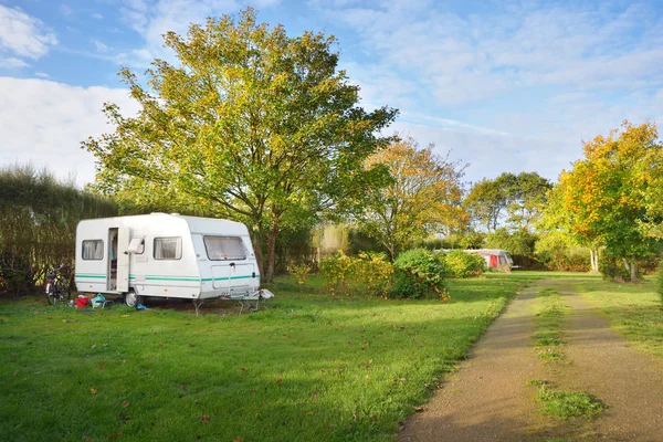 Caravan trailer på en grön gräsmatta under träden — Stockfoto