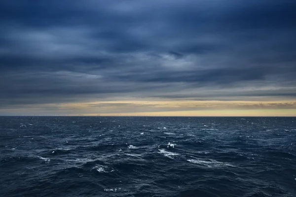 Paisaje marino con turbinas eólicas en alta mar en una puesta de sol en el mar — Foto de Stock