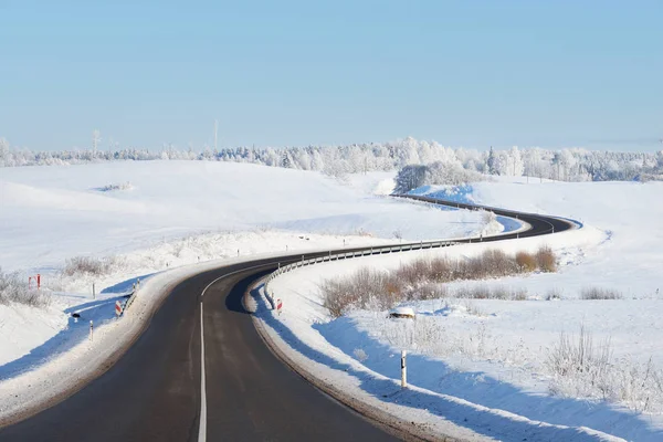 Autostrada forestale in discesa con cartello in inverno — Foto Stock