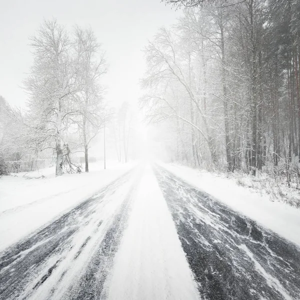 ブリザードの間に雪に覆われた冬の道 — ストック写真