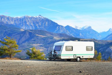 Bir dağın tepesinde bir bisiklet ile karavan Park 