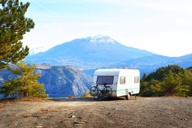 Bir dağın tepesinde bir bisiklet ile karavan Park 