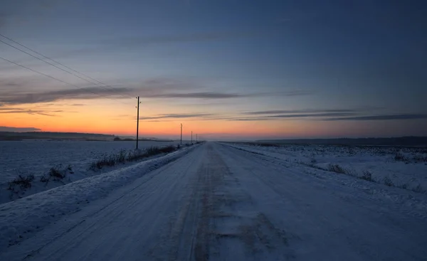 Estrada do campo com postes de telégrafo no inverno — Fotografia de Stock