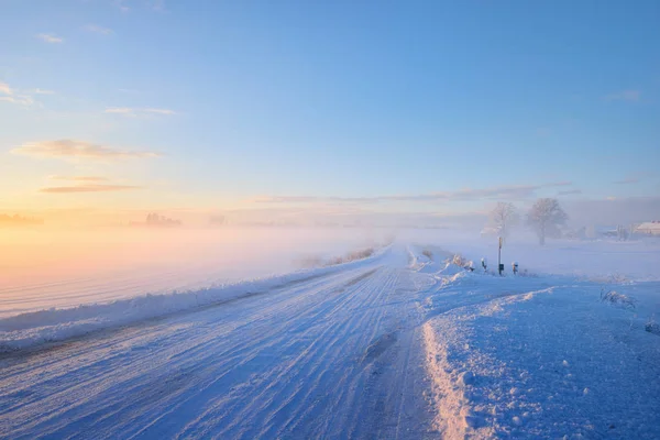 Ομίχλη πάνω από έναν αυτοκινητόδρομο snowcovered κατά τη διάρκεια Χειμώνας ηλιοβασίλεμα — Φωτογραφία Αρχείου