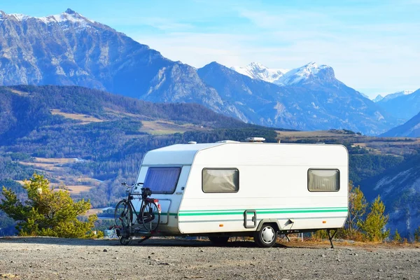 Caravan met een fiets geparkeerd op een bergtop — Stockfoto