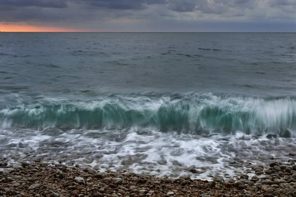 Oceaan golven die breken tegen kiezelstrand — Stockfoto