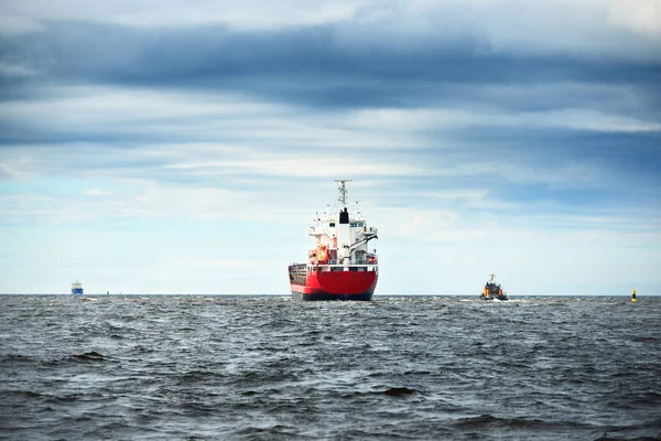 Algemene vrachtschip naast een sleepboot in een zee — Stockfoto