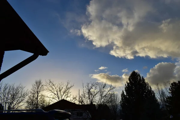 Sonnenuntergang Wolken Und Blauer Himmel Über Bäumen Und Silhouettenhäusern — Stockfoto