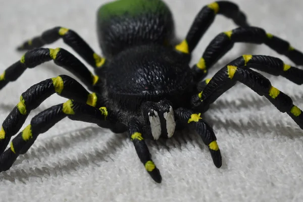 Black Yellow Green Toy Tarantula Facing Camera White Cloth — Stock Photo, Image