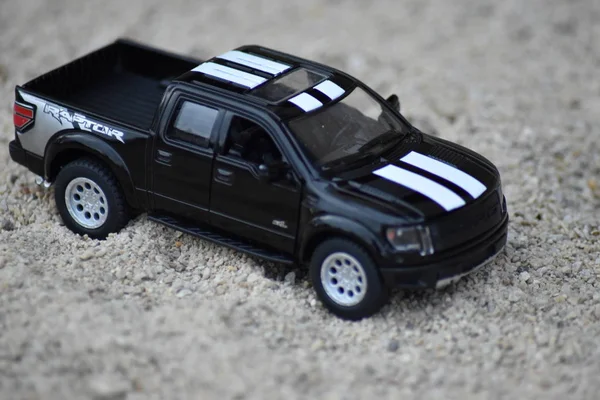 Camión Juguete Negro Con Rayas Blancas Conduciendo Arena Playa — Foto de Stock