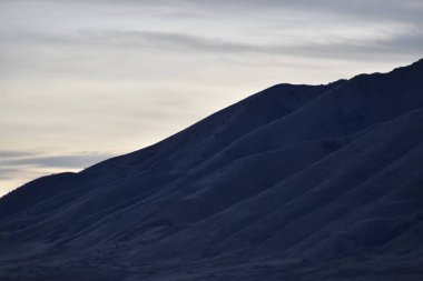 Işık bulutlu gökyüzü ile mavi dağ yamaçları. 