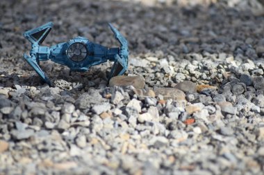 Mavi ve siyah uzay savaşçısı küçük kaya zemininde.