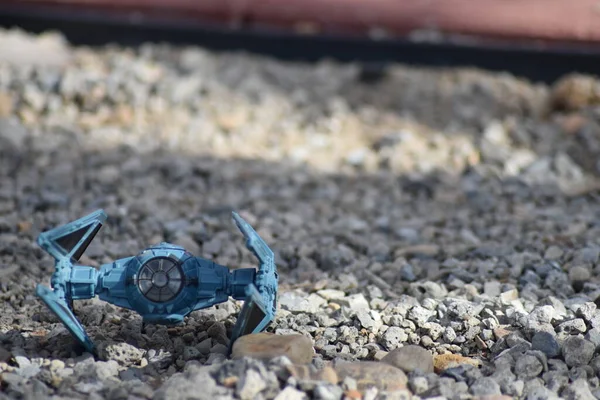 Kırmızı ahşap arka planı olan çakıllı zeminde özel bir uzay savaşçısı..