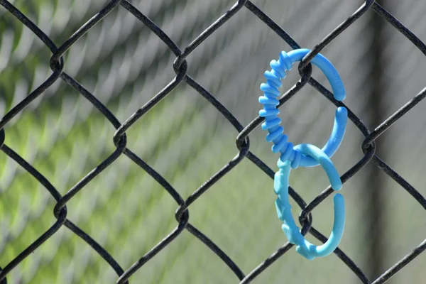 Mavi halka çocuklar bağlanmış ve tel örgüye bağlanmış..