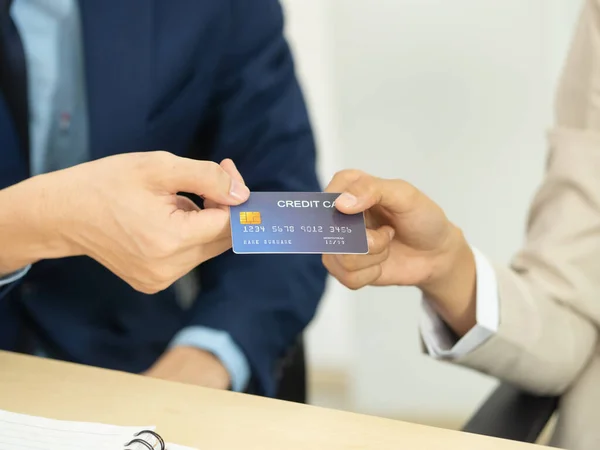 Kapalı çekim bir kredi kartı tutuyor ve başka birine geçiyor. Mali, bankacılık ve çevrimiçi alışveriş kavramları
